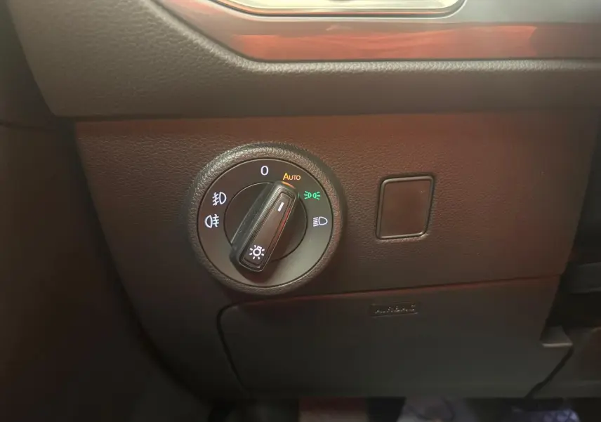 Gros plan sur le bouton de commande des phares du SEAT Ateca 2025, avec éclairage automatique activé.