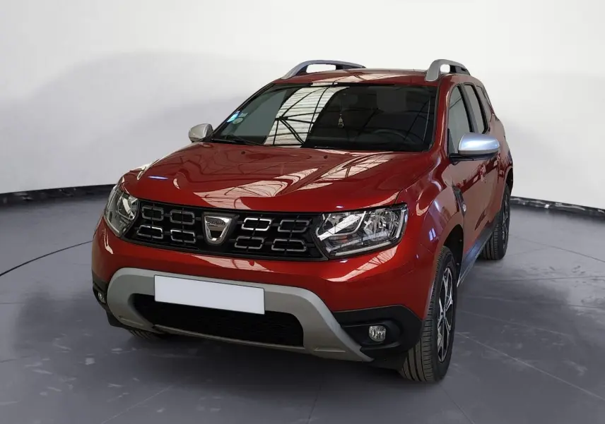 Dacia Duster rouge fusion en 3/4 avant droit, avec calandre noire et jantes alliage 17 pouces visibles.