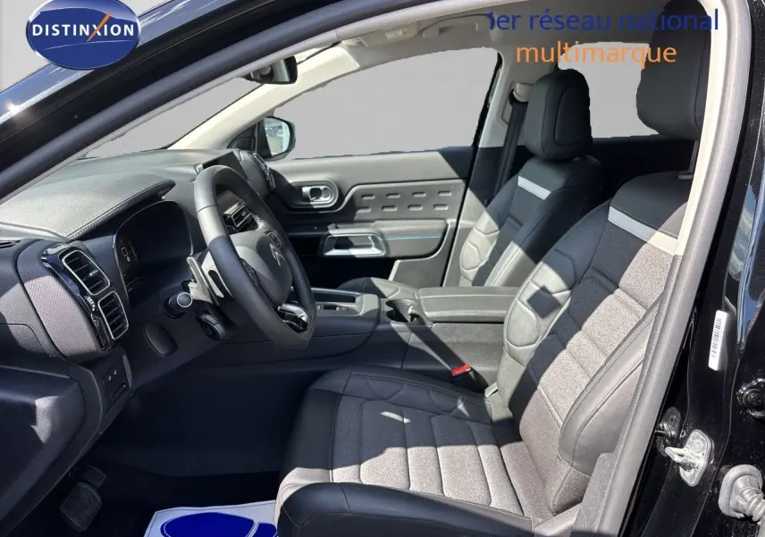 Vue intérieure côté conducteur du Citroën C5 Aircross noir Perla Nera, sièges tissu et cuir avec volant multifonction.