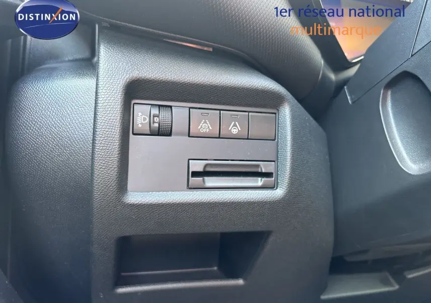 Gros plan sur les commandes de réglage d’éclairage et d’aide à la conduite côté gauche du tableau de bord noir du Citroën C5 Aircross 2025.