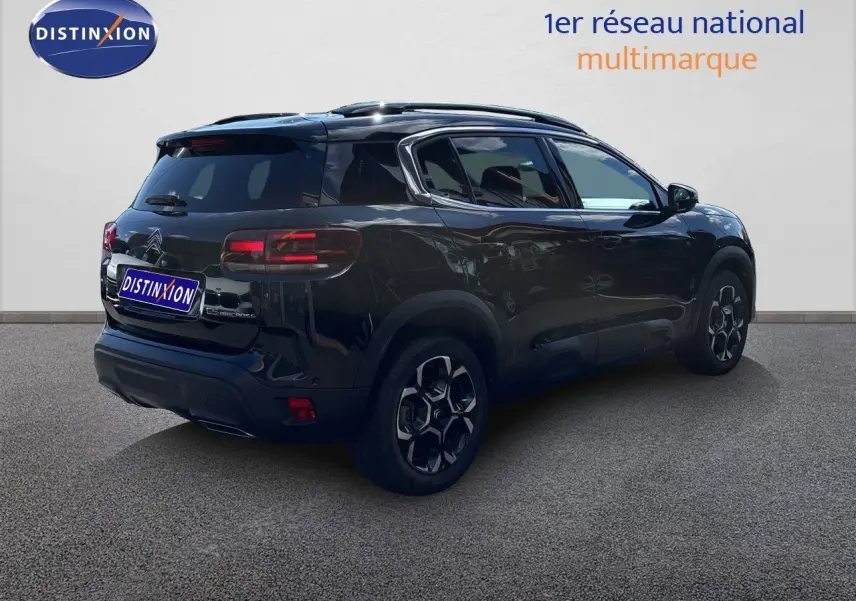 Vue 3/4 arrière droite d'un Citroën C5 Aircross noir Perla Nera métallisé avec jantes noires et toit panoramique.