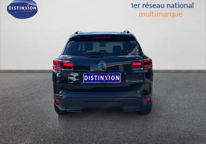 Vue arrière d'un Citroën C5 Aircross noir Perla Nera metal, mettant en valeur ses feux et son design compact.