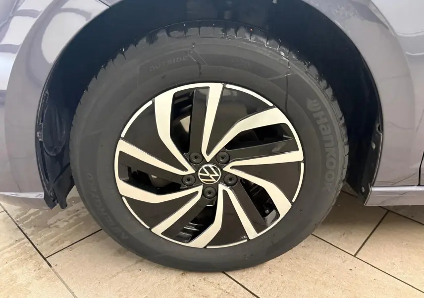 Gros plan sur la roue avant gauche d’une Volkswagen Polo gris cendre 2024 avec jante alliage noire et argent.