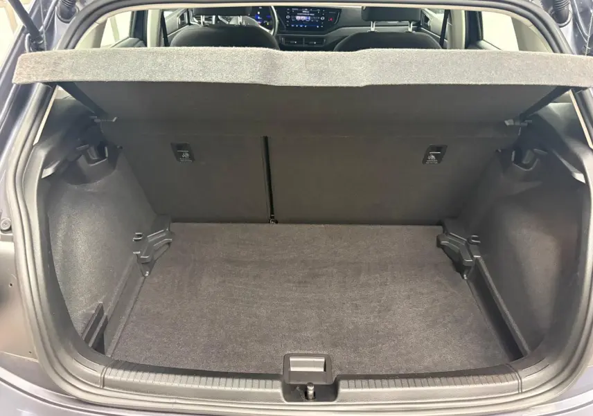 Coffre ouvert d’une Volkswagen Polo gris cendre 2024, vue arrière montrant l’espace de chargement et l’intérieur du véhicule.