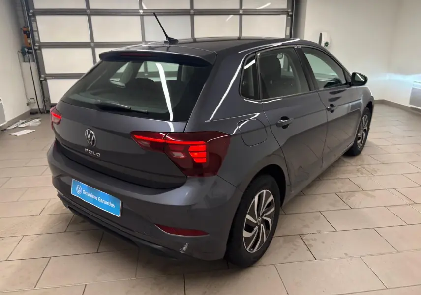 Volkswagen Polo gris cendre vue 3/4 arrière droit en intérieur, avec feux arrière LED et jantes alliage.
