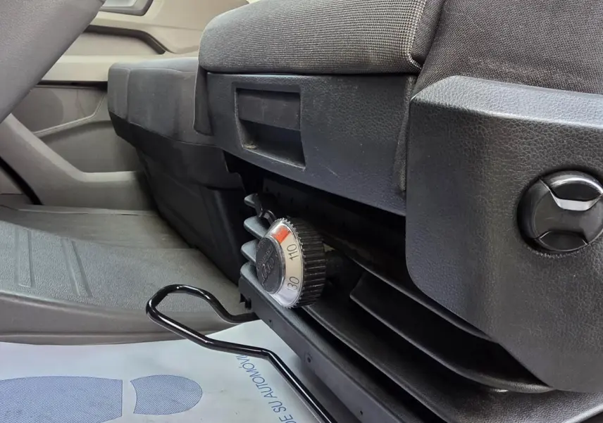 Vue rapprochée du réglage de siège noir dans l'habitacle du Volkswagen Crafter Fourgon blanc 2023.