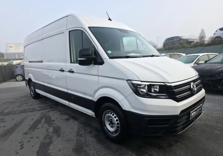Volkswagen Crafter Fourgon blanc en 3/4 avant droit avec jantes acier et pare-chocs noirs contrastés.