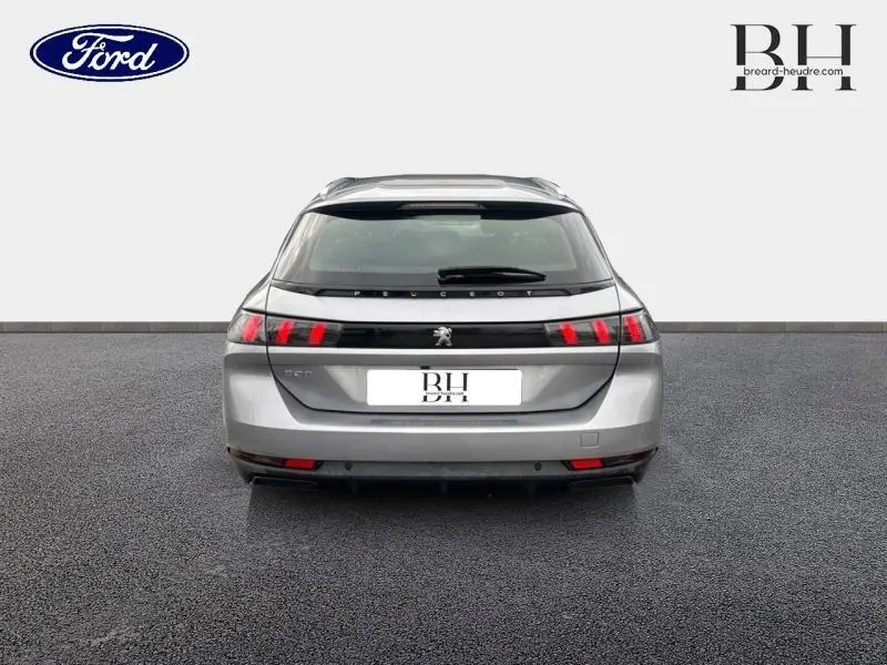 Vue arrière d'une Peugeot 508 SW gris Platinium avec feux arrière à LED et hayon ouvert sur fond neutre.