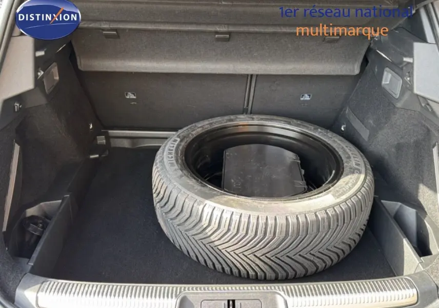 Coffre ouvert d’un DS7 1.5 BlueHDi 130 noir perle, vue plongeante sur la roue de secours et l’espace de rangement.