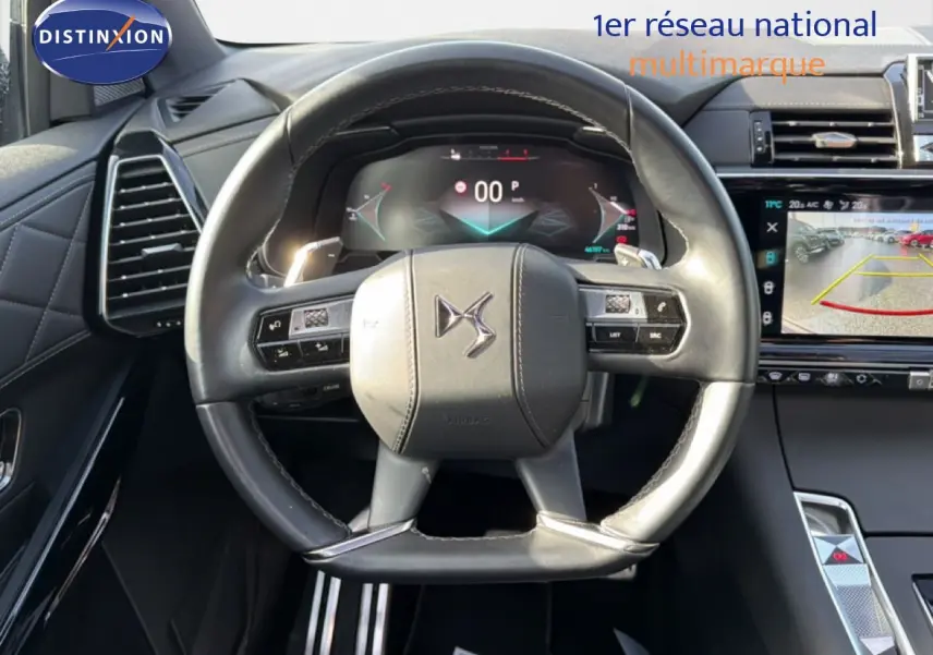 Vue rapprochée du volant cuir noir perle du DS7 2024 avec tableau de bord numérique et écran central tactile.