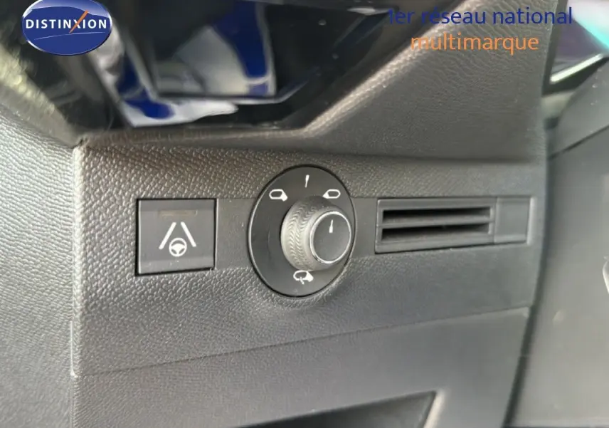 Gros plan sur les commandes de réglage des phares et l’assistance au maintien de voie dans l’habitacle noir du DS7 2024.