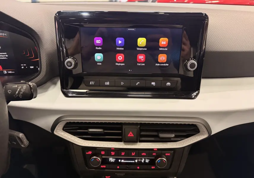 Tableau de bord de la SEAT Ibiza 2025 avec écran tactile central et commandes de climatisation en vue frontale rapprochée.