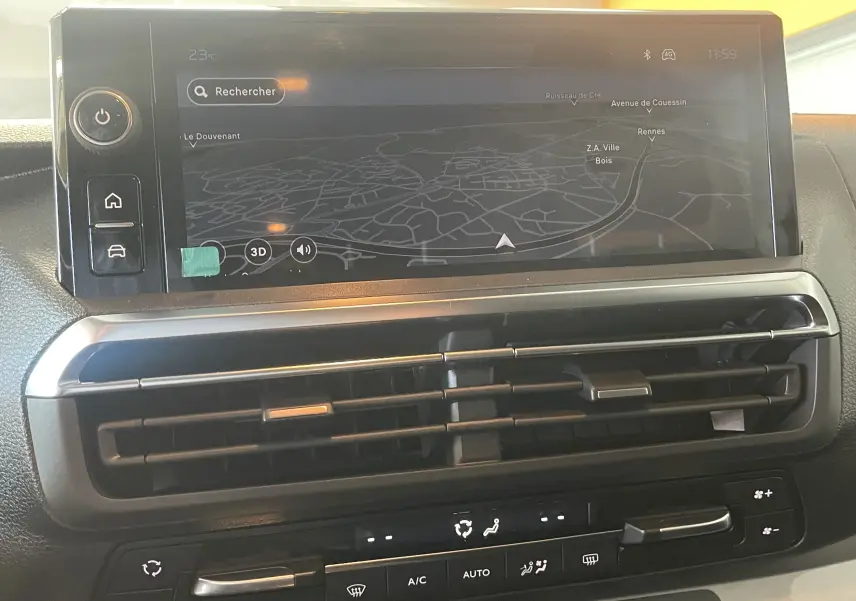 Vue rapprochée de l’écran tactile central noir du Peugeot Traveller 2026 avec navigation et commandes de climatisation.