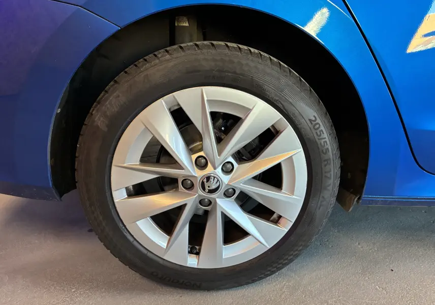 Gros plan sur la roue avant gauche d’une Skoda Octavia Combi bleu 2024 avec jante alliage à 5 branches doubles.