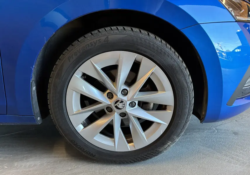 Gros plan sur la roue avant droite d'une Skoda Octavia Combi bleu 2024, mettant en valeur la jante argentée au design moderne.