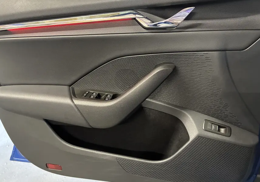 Vue rapprochée de la porte intérieure côté gauche de la Skoda Octavia Combi 2024, avec garniture noire et commandes de fenêtres.
