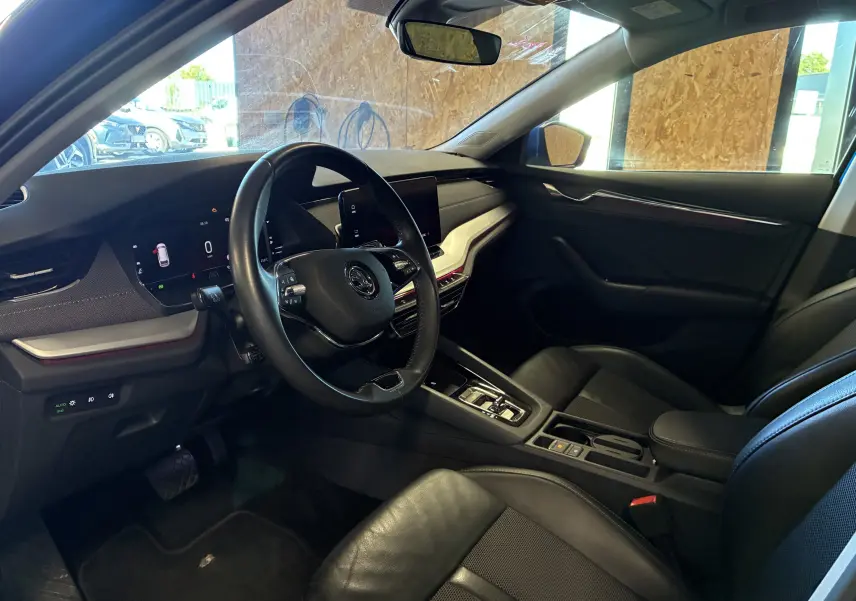 Vue intérieure côté conducteur de la Skoda Octavia Combi 2024, tableau de bord noir avec écran digital et volant multifonction.