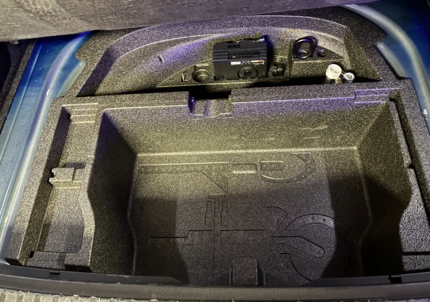 Vue plongeante sur le coffre ouvert d’une Skoda Octavia Combi 2024 bleu, montrant le rangement en mousse vide.