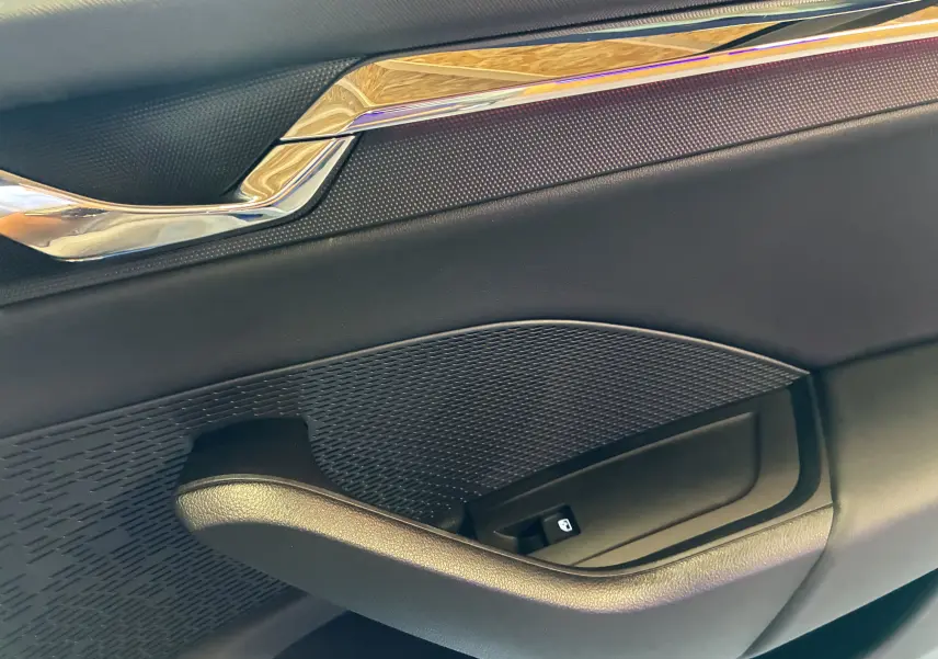 Détail de la poignée intérieure côté droit de la porte noire d'une Skoda Octavia Combi 2024 avec insert chromé.