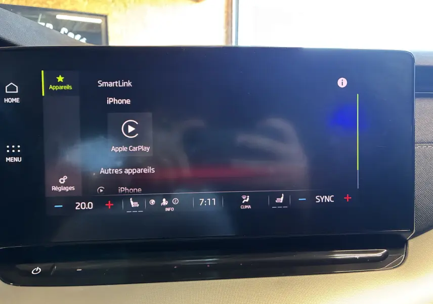 Écran tactile central de la Skoda Octavia Combi 2024 bleu, affichant la connexion Apple CarPlay et les réglages climatisation.