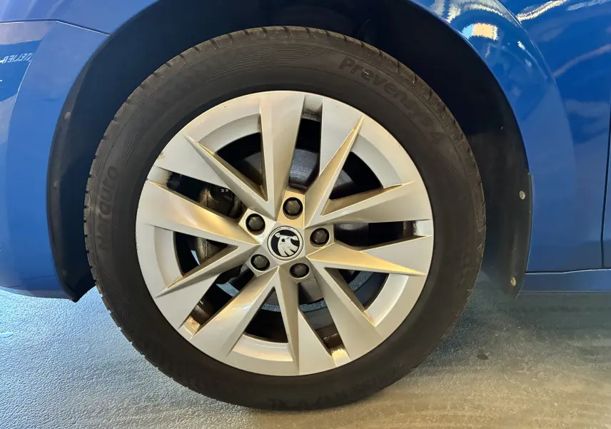 Gros plan sur la roue avant gauche d'une Skoda Octavia Combi bleu 2024 avec jante alliage à 10 branches.