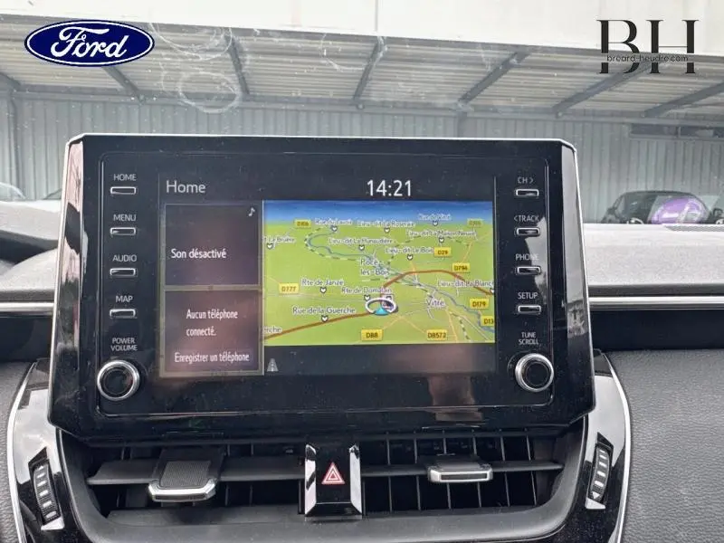 Écran tactile central avec navigation GPS affichée, vue de face de l'intérieur d'un Toyota Corolla gris Manhattan.