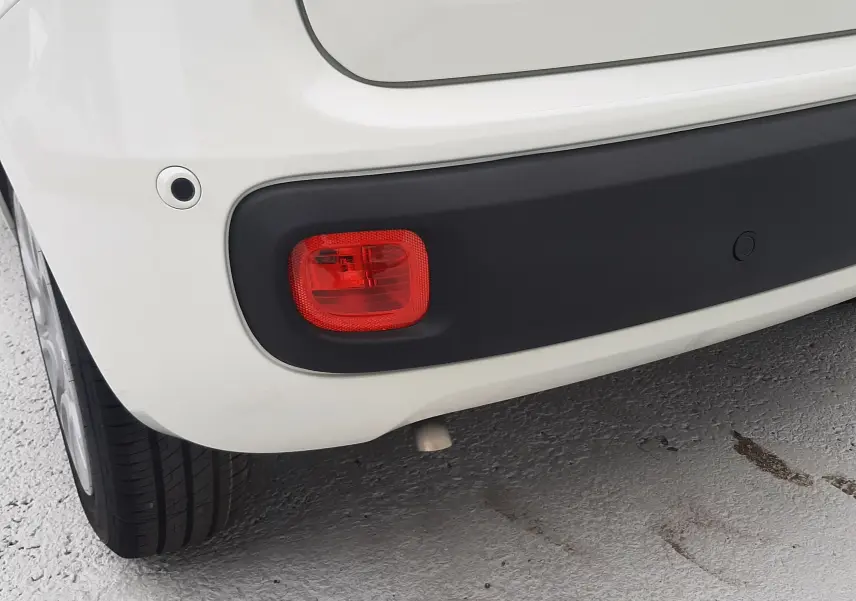 Gros plan sur le feu arrière droit et le pare-chocs noir d'une Fiat Panda 1.0 blanc gelato, vue arrière côté droit.