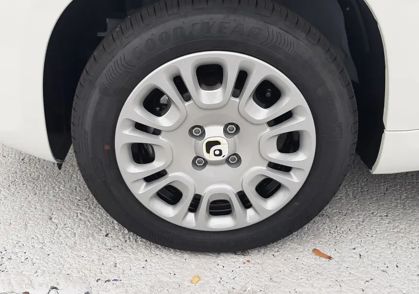 Gros plan sur la roue avant droite de la Fiat Panda 2025 blanc gelato avec jante en alliage et pneu Goodyear.