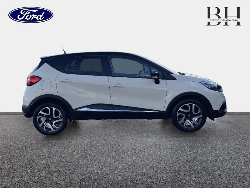 Profil droit d'un Renault Captur beige cendré avec toit noir étoilé, jantes alu et lignes noires contrastantes.