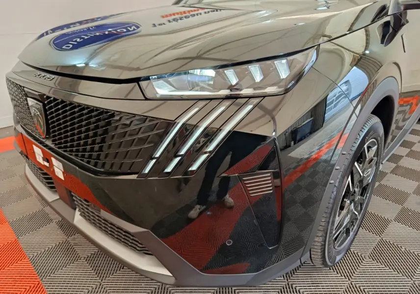 Vue 3/4 avant droit du Peugeot 3008 noir 2025 avec phares LED et calandre distinctive GT.