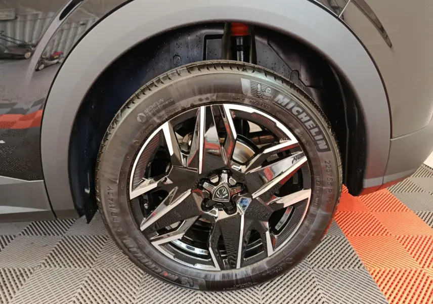 Gros plan sur la roue avant droite noire avec jante alliage distinctive du Peugeot 3008 HYBRID 145 GT 2025.