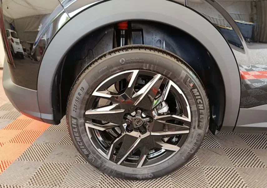 Gros plan sur la roue avant droite noire du Peugeot 3008 1.2 HYBRID 145 GT avec jante alliage et pneu Michelin.