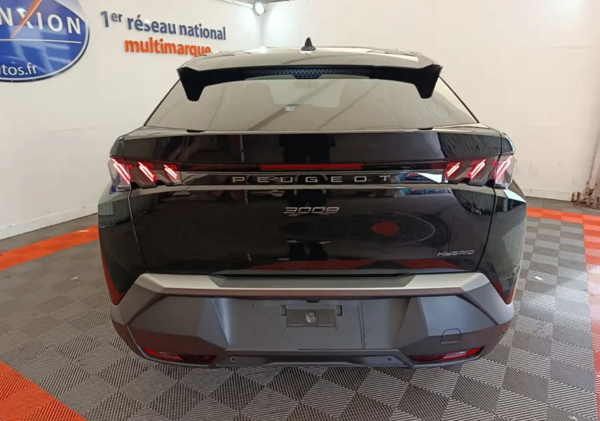 Vue arrière du Peugeot 3008 noir hybride 2025 avec feux arrière LED en forme de griffes et logo central lumineux.