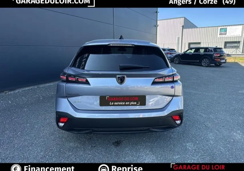 Vue arrière d'une Peugeot 308 gris clair 2023 avec feux LED et logo lion distinctif.