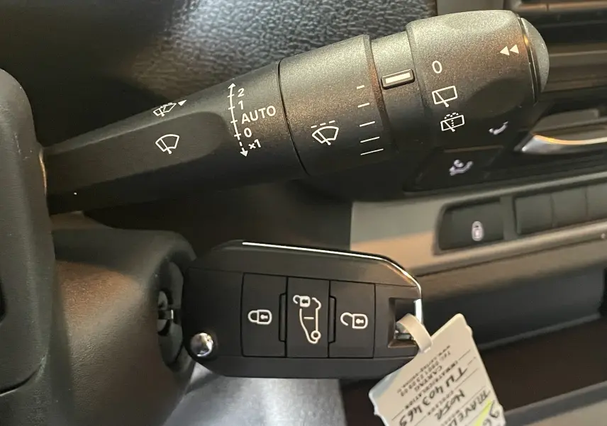 Gros plan sur la commande d’essuie-glace et la clé noire insérée dans le contacteur du Peugeot Traveller 2026.