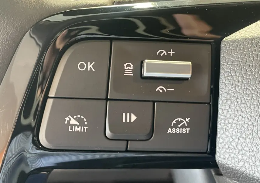 Gros plan sur les commandes noires du volant du Peugeot Traveller 2026, avec boutons de régulateur et assistant de conduite.