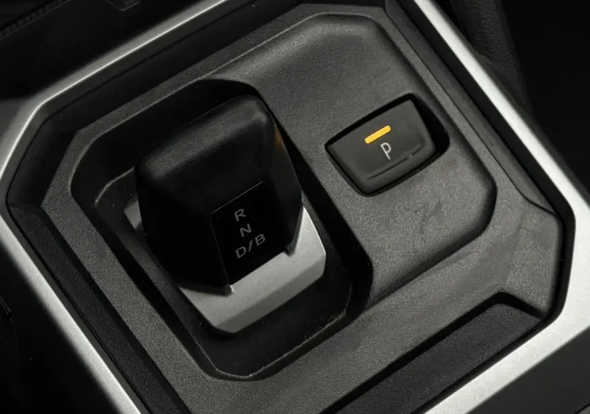 Gros plan sur le levier de vitesses automatique et le bouton de stationnement électrique du Dacia Duster 2026.