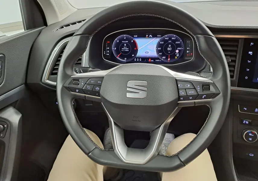 Vue rapprochée du volant multifonction noir du SEAT Ateca 2025 avec tableau de bord numérique allumé.