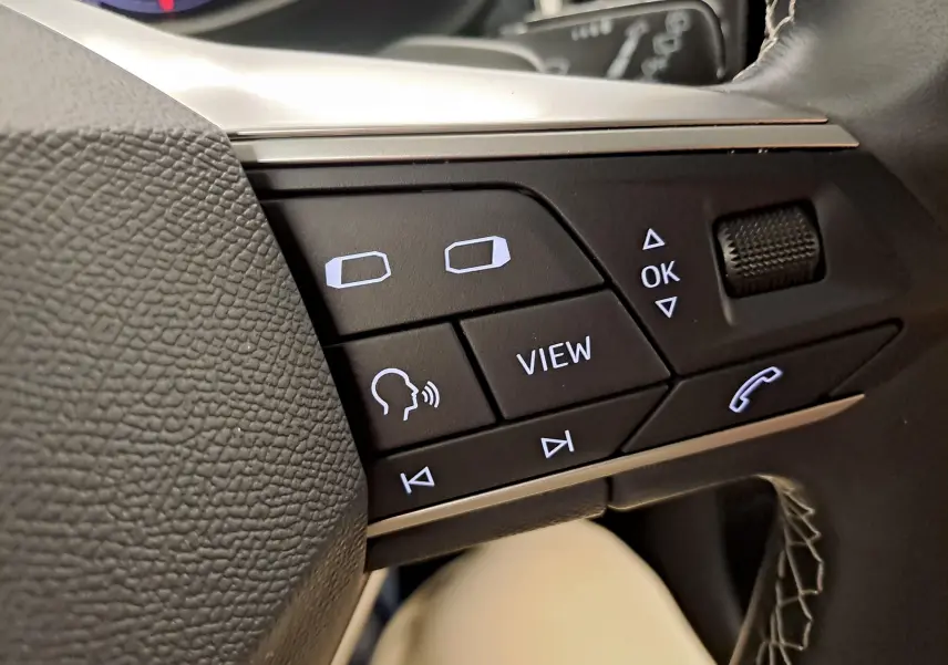 Gros plan sur les commandes au volant du SEAT Ateca 2.0 TDI 150 DSG7 Copa, boutons noirs avec symboles blancs.