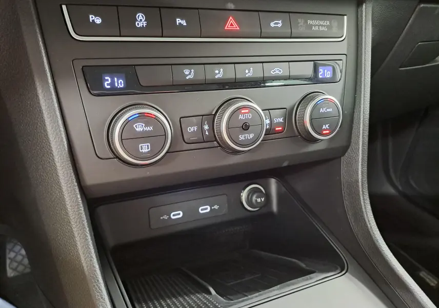 Gros plan sur la console centrale du SEAT Ateca 2025, montrant les commandes de climatisation et ports USB.