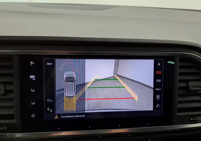 Vue écran multimédia montrant la caméra de recul du SEAT Ateca argent, avec guidage de trajectoire coloré.