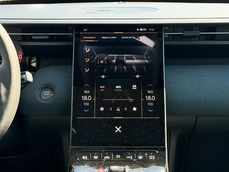 Vue rapprochée de l’écran tactile central noir du tableau de bord du Citroën C5 Aircross 2026 avec commandes climatisation affichées.
