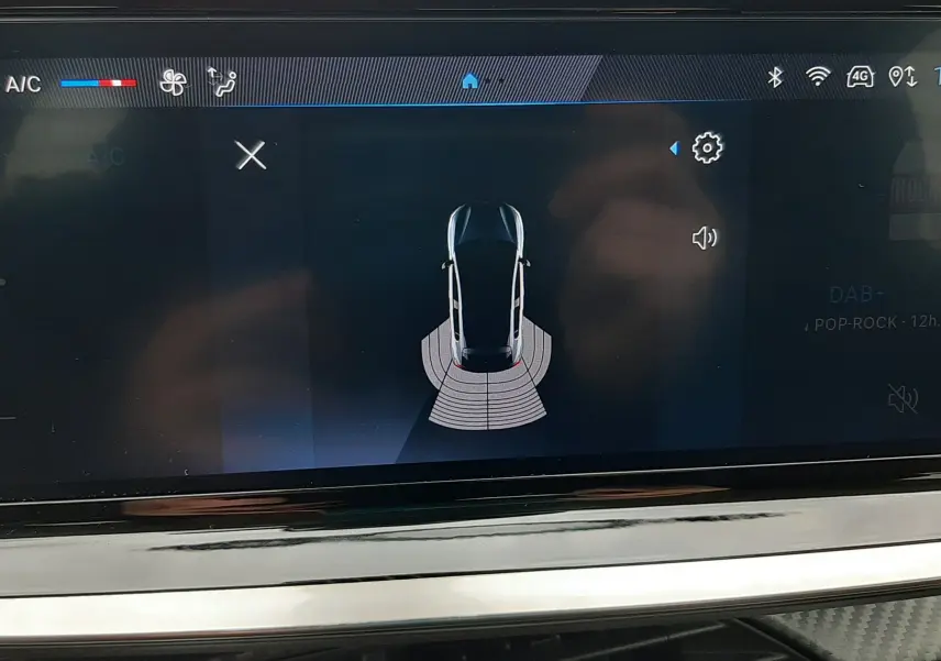 Écran tactile intérieur montrant l'alerte de proximité arrière du Peugeot 208 gris selenium, version 2024.