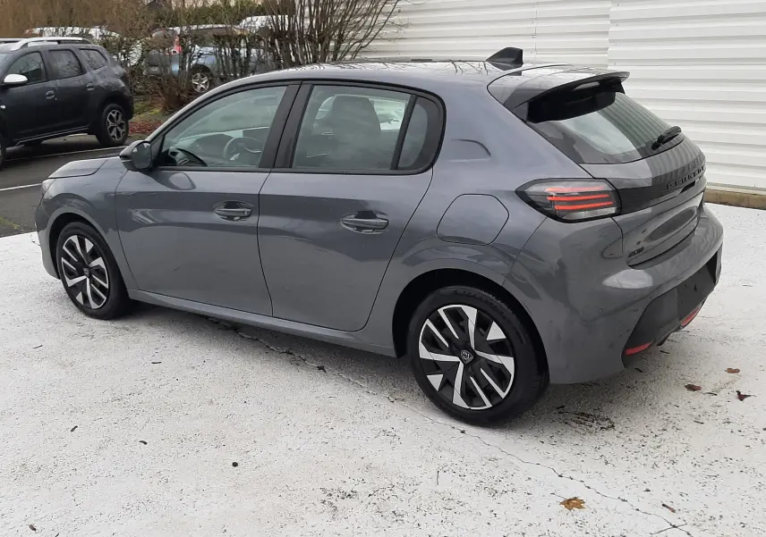 Peugeot 208 gris sélénium vue 3/4 arrière côté gauche, avec jantes alliage et toit avec antenne requin.