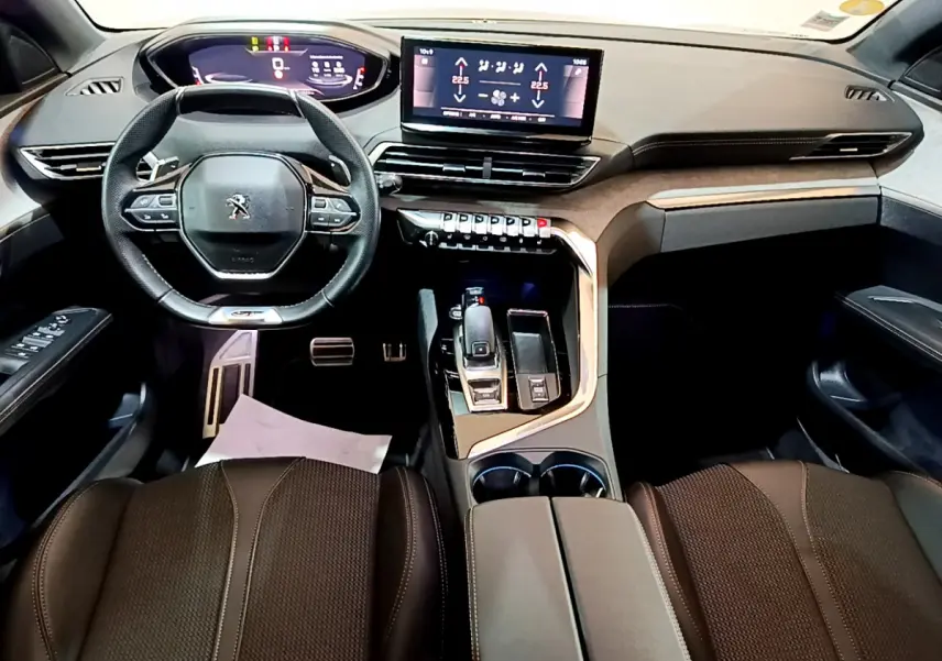 Intérieur Peugeot 3008 GT 2023 vu de face, tableau de bord moderne avec écran tactile central et volant compact cuir.