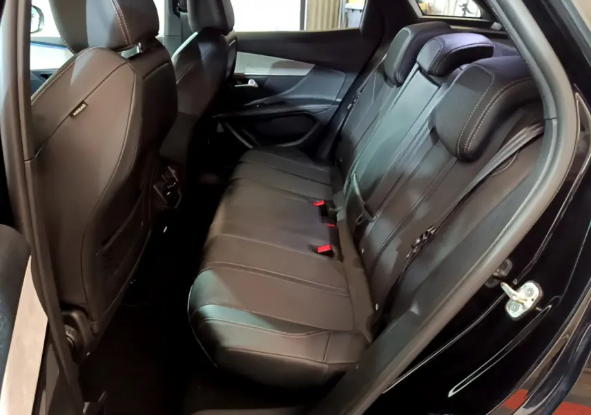 Vue intérieure côté droit des sièges arrière noirs en cuir du Peugeot 3008 GT 2023 avec surpiqûres blanches.