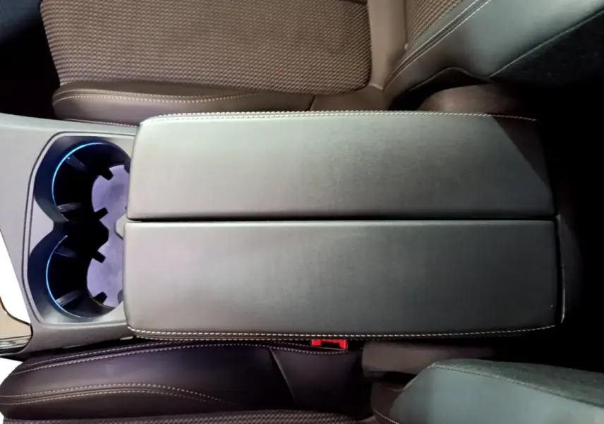 Vue plongeante sur l'accoudoir central noir et les sièges marron du Peugeot 3008 GT 2023 intérieur cuir et tissu