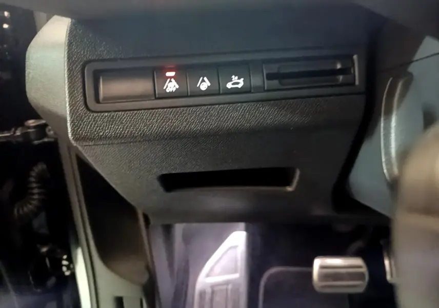 Gros plan sur les commandes sous le tableau de bord du Peugeot 3008 noir, avec pédale d'accélérateur visible à droite.