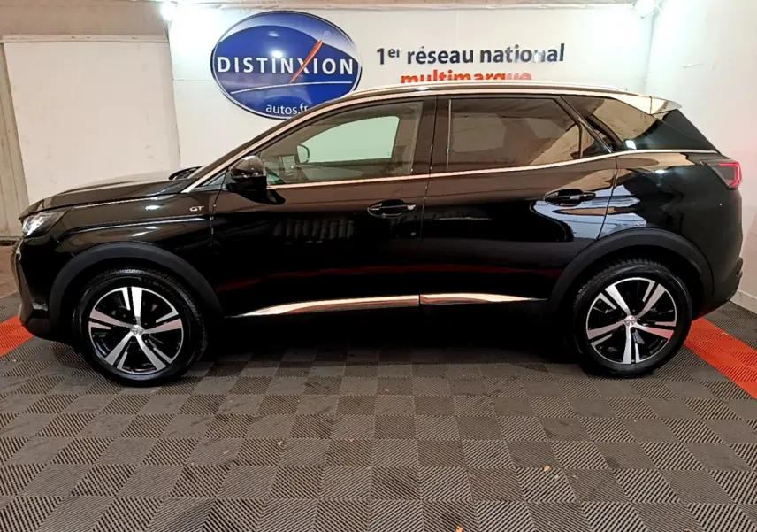 Profil côté gauche d'un Peugeot 3008 GT noir 2023, avec jantes alliage et vitres teintées en intérieur showroom.