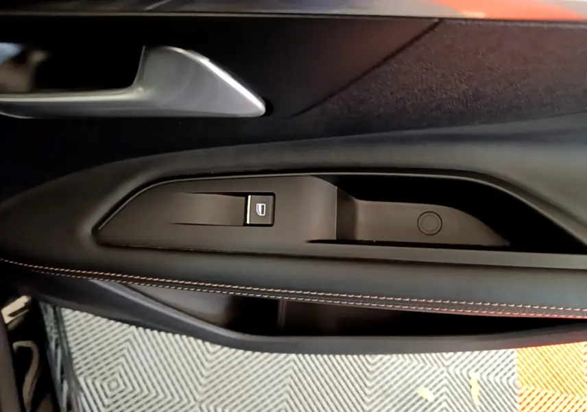 Gros plan sur la poignée intérieure et commande de lève-vitre côté gauche du Peugeot 3008 GT noir 2023.